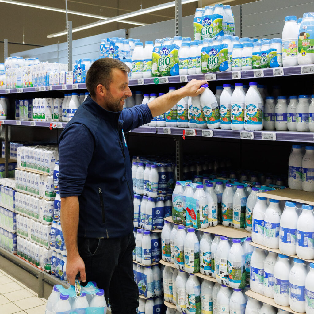 Matthieu Poiroux, éleveur laitier, devant les produits Juste et Vendéen d'un rayon de supermarché Super U en Vendée (85). © Thomas LOUAPRE / Divergence