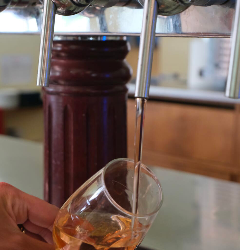 Verre en train d'être rempli de vin grâce à une tireuse